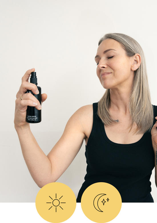 Someone holds an AMLY mist in front of their face. there are also two icons, one of a sun and one of a moon that indicates this is for daytime and nighttime use
