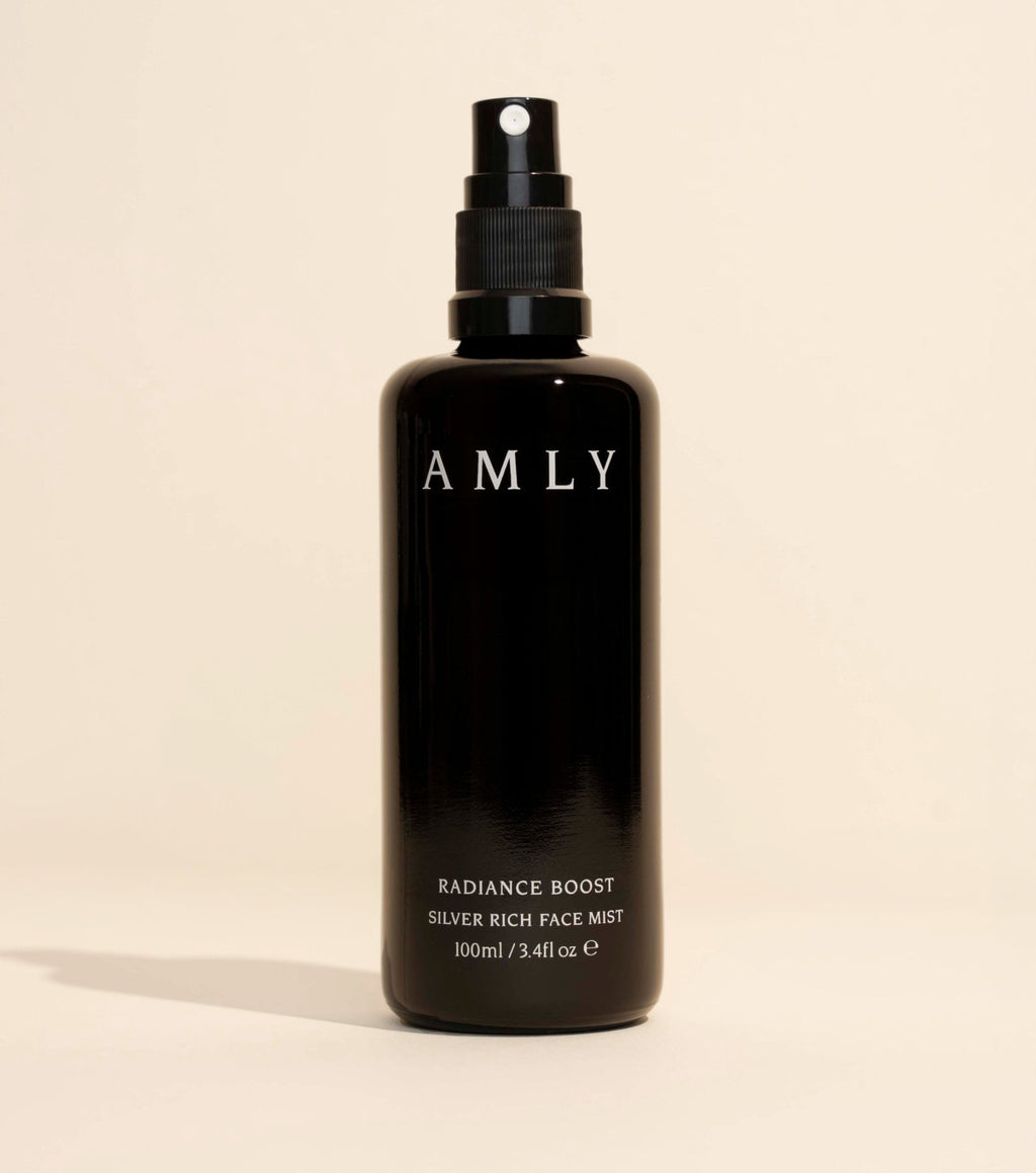 AMLY Radiance Boost Face Mist in a black glass spray bottle on a beige background